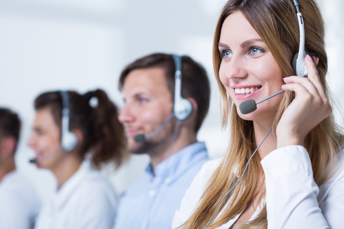 A woman smiling while wearing a VoIP headset